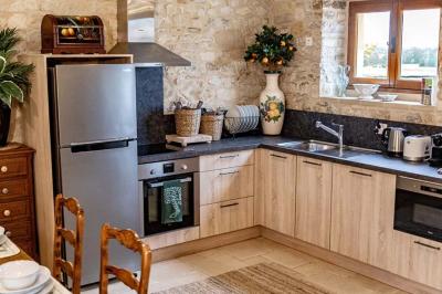Table élégamment dressée avec chandeliers noirs, verres en cristal et nappes blanches dans une salle au style rustique.