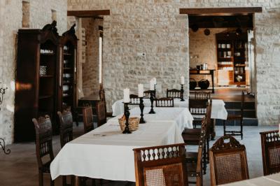 Table élégamment dressée avec chandeliers noirs, verres en cristal et nappes blanches dans une salle au style rustique.