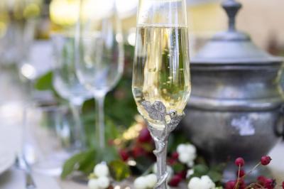 Table élégamment dressée avec chandeliers noirs, verres en cristal et nappes blanches dans une salle au style rustique.