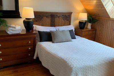 Table élégamment dressée avec chandeliers noirs, verres en cristal et nappes blanches dans une salle au style rustique.