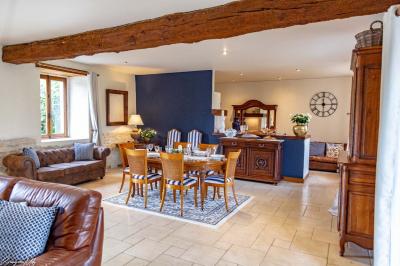 Cheval brun avec une marque blanche sur le front broutant de l'herbe dans un champ verdoyant.