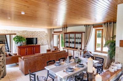 Cheval brun avec une marque blanche sur le front broutant de l'herbe dans un champ verdoyant.