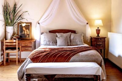 Cheval brun avec une marque blanche sur le front broutant de l'herbe dans un champ verdoyant.