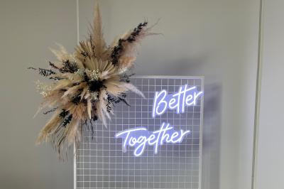 Composition florale dans une coupe en métal doré, avec des fleurs rouges, blanches et feuillages verts.