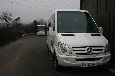 Vue intérieure d'un autocar avec des sièges rembourrés et un toit vitré laissant passer la lumière naturelle.