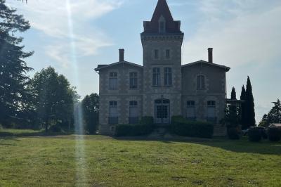 Intérieur d'une tente éclairée en rouge, avec des tables rondes et des chaises blanches disposées pour un événement.