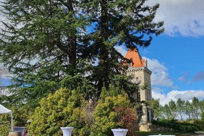Intérieur d'une tente éclairée en rouge, avec des tables rondes et des chaises blanches disposées pour un événement.