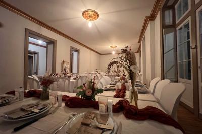 Intérieur d'une tente éclairée en rouge, avec des tables rondes et des chaises blanches disposées pour un événement.