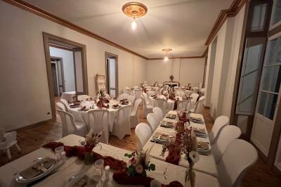 Intérieur d'une tente éclairée en rouge, avec des tables rondes et des chaises blanches disposées pour un événement.