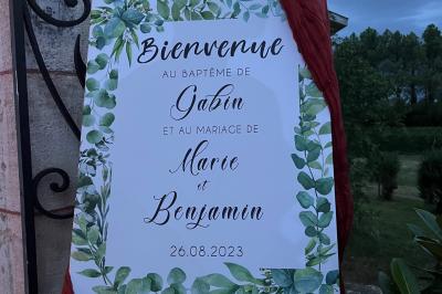 Intérieur d'une tente éclairée en rouge, avec des tables rondes et des chaises blanches disposées pour un événement.