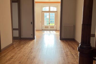 Intérieur d'une tente éclairée en rouge, avec des tables rondes et des chaises blanches disposées pour un événement.