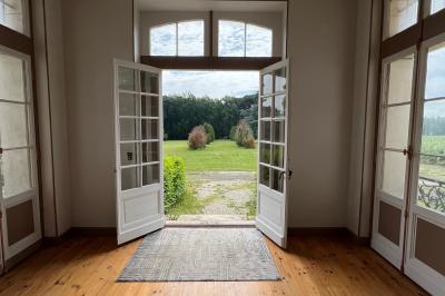 Intérieur d'une tente éclairée en rouge, avec des tables rondes et des chaises blanches disposées pour un événement.
