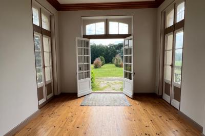 Intérieur d'une tente éclairée en rouge, avec des tables rondes et des chaises blanches disposées pour un événement.