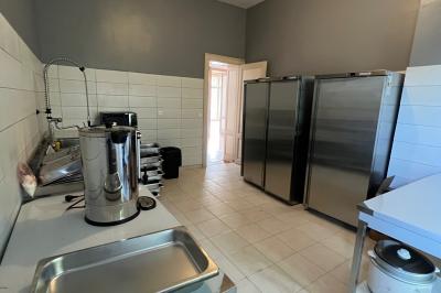 Intérieur d'une tente éclairée en rouge, avec des tables rondes et des chaises blanches disposées pour un événement.