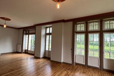 Intérieur d'une tente éclairée en rouge, avec des tables rondes et des chaises blanches disposées pour un événement.
