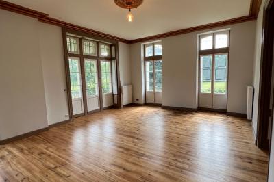 Intérieur d'une tente éclairée en rouge, avec des tables rondes et des chaises blanches disposées pour un événement.