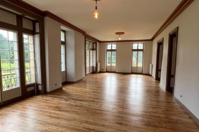 Intérieur d'une tente éclairée en rouge, avec des tables rondes et des chaises blanches disposées pour un événement.