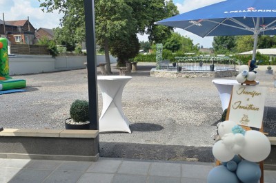 Salle de réception élégante décorée de nappes blanches, chaises habillées et centres de table floraux.