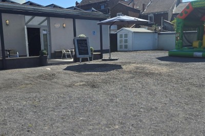 Salle de réception élégante décorée de nappes blanches, chaises habillées et centres de table floraux.