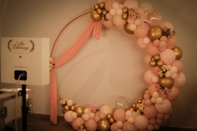 Salle de réception élégante décorée de nappes blanches, chaises habillées et centres de table floraux.