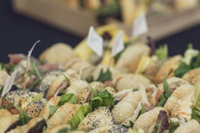 Des personnes se servent à un buffet dans un espace intérieur lumineux avec des boissons et des aliments disposés sur une…