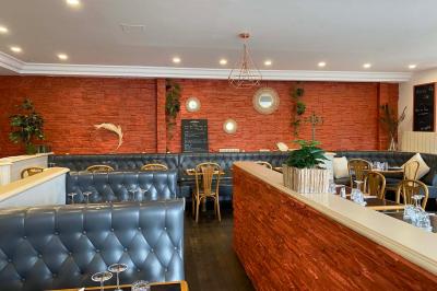 Dessert au chocolat avec framboises fraîches, éclats de biscuit et coulis, présenté sur une assiette en ardoise.