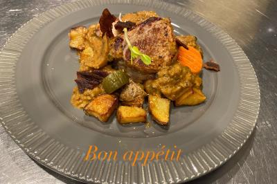 Dessert au chocolat avec framboises fraîches, éclats de biscuit et coulis, présenté sur une assiette en ardoise.