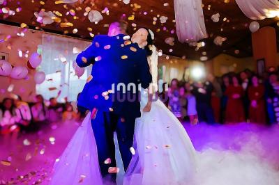 Tables hautes blanches dressées sur une pelouse avec des tonnelles blanches en arrière-plan.