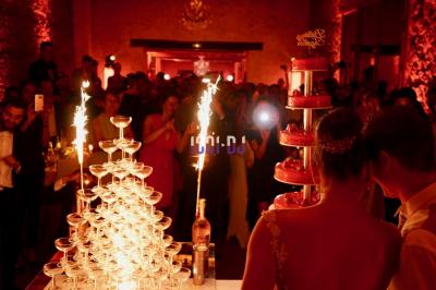 Tables hautes blanches dressées sur une pelouse avec des tonnelles blanches en arrière-plan.