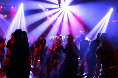 Tables hautes blanches dressées sur une pelouse avec des tonnelles blanches en arrière-plan.