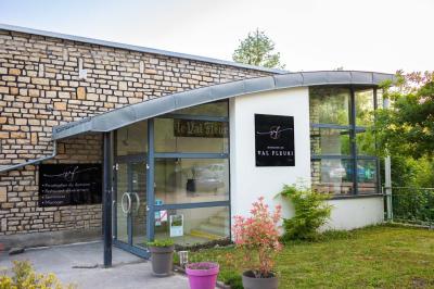 Salle de réception décorée avec de longues tables dressées, des chaises dorées et des nuages suspendus au plafond.