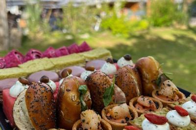 Salle de réception décorée avec de longues tables dressées, des chaises dorées et des nuages suspendus au plafond.