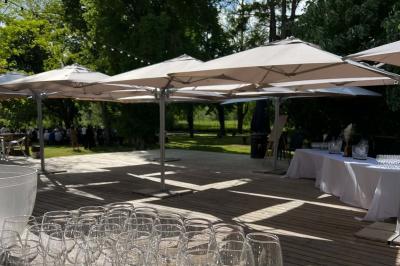 Salle de réception décorée avec de longues tables dressées, des chaises dorées et des nuages suspendus au plafond.