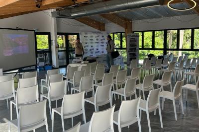 Salle de réception décorée avec de longues tables dressées, des chaises dorées et des nuages suspendus au plafond.