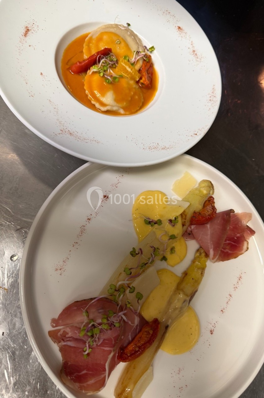 Assiette de ravioles en sauce et assiette d'asperges avec jambon cru, tomates confites et sauce hollandaise.
