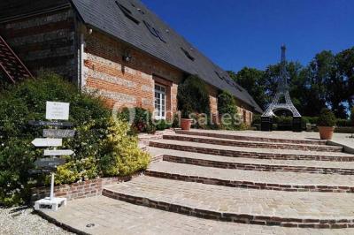 Deux tentes blanches installées sur une pelouse entourée de végétation et d'arbres sous un ciel bleu.