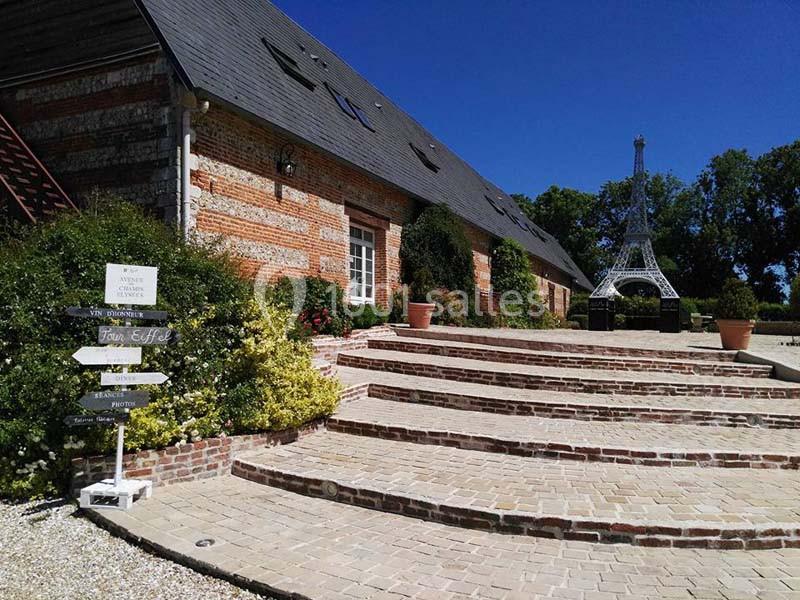 Escalier en briques menant à une maison en pierre avec une réplique de la tour Eiffel dans un jardin.
