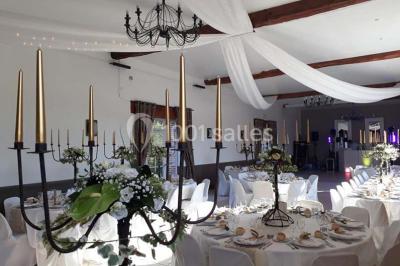 Deux tentes blanches installées sur une pelouse entourée de végétation et d'arbres sous un ciel bleu.