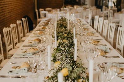 Deux tentes blanches installées sur une pelouse entourée de végétation et d'arbres sous un ciel bleu.