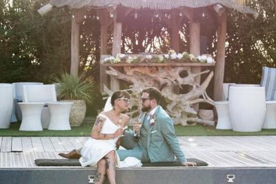 Salle de réception élégante avec tables rondes décorées de fleurs blanches et serviettes pliées, ambiance lumineuse.