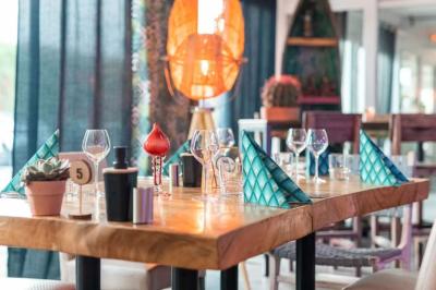 Salle de réception élégante avec tables rondes décorées de fleurs blanches et serviettes pliées, ambiance lumineuse.