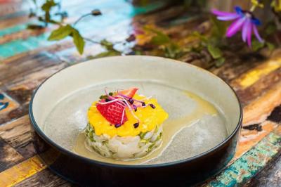 Salle de réception élégante avec tables rondes décorées de fleurs blanches et serviettes pliées, ambiance lumineuse.