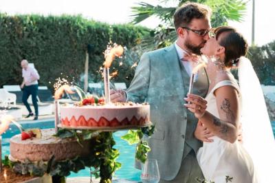 Salle de réception élégante avec tables rondes décorées de fleurs blanches et serviettes pliées, ambiance lumineuse.