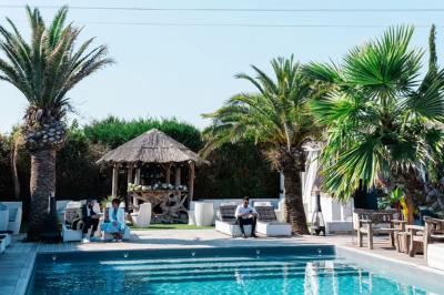 Salle de réception élégante avec tables rondes décorées de fleurs blanches et serviettes pliées, ambiance lumineuse.