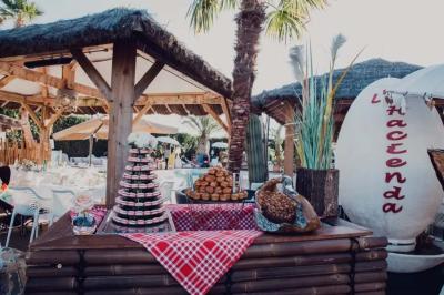 Salle de réception élégante avec tables rondes décorées de fleurs blanches et serviettes pliées, ambiance lumineuse.
