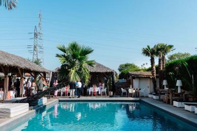 Salle de réception élégante avec tables rondes décorées de fleurs blanches et serviettes pliées, ambiance lumineuse.