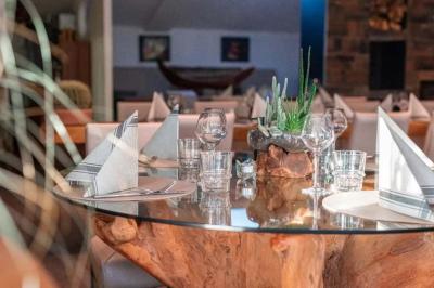 Salle de réception élégante avec tables rondes décorées de fleurs blanches et serviettes pliées, ambiance lumineuse.