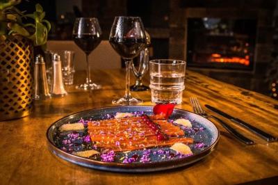 Salle de réception élégante avec tables rondes décorées de fleurs blanches et serviettes pliées, ambiance lumineuse.