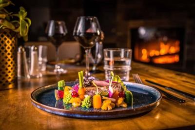 Salle de réception élégante avec tables rondes décorées de fleurs blanches et serviettes pliées, ambiance lumineuse.
