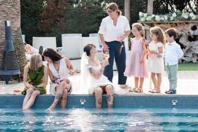 Salle de réception élégante avec tables rondes décorées de fleurs blanches et serviettes pliées, ambiance lumineuse.